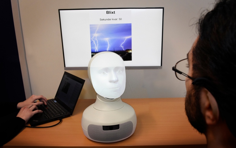 En människa samspelar med ett robotansikte